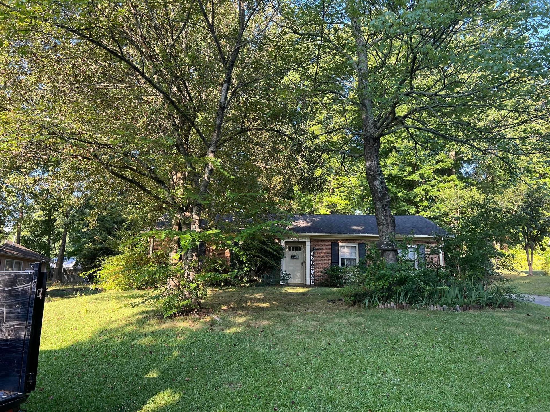 A small house with a lot of trees in front of it.
