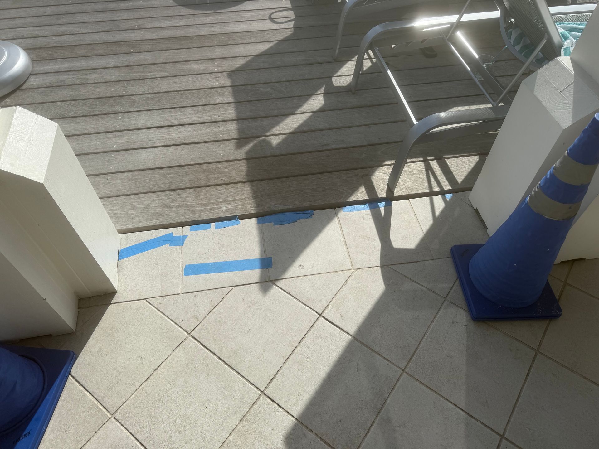 Blue cones and white pillars on tiled floor; sunlight and shadows.