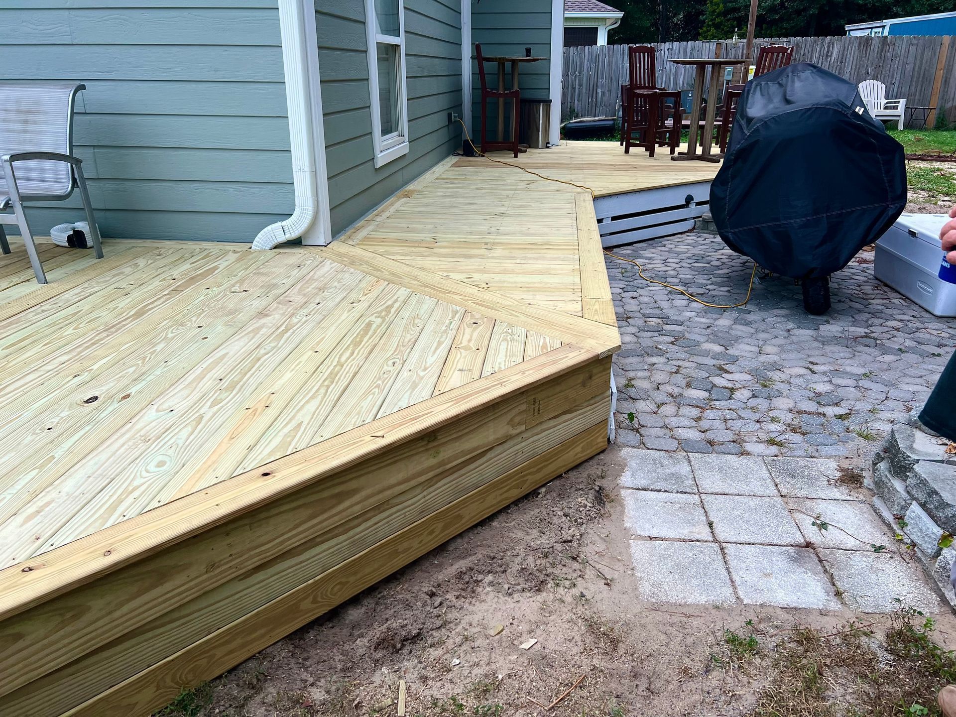 A wooden deck is being built in the backyard of a house.