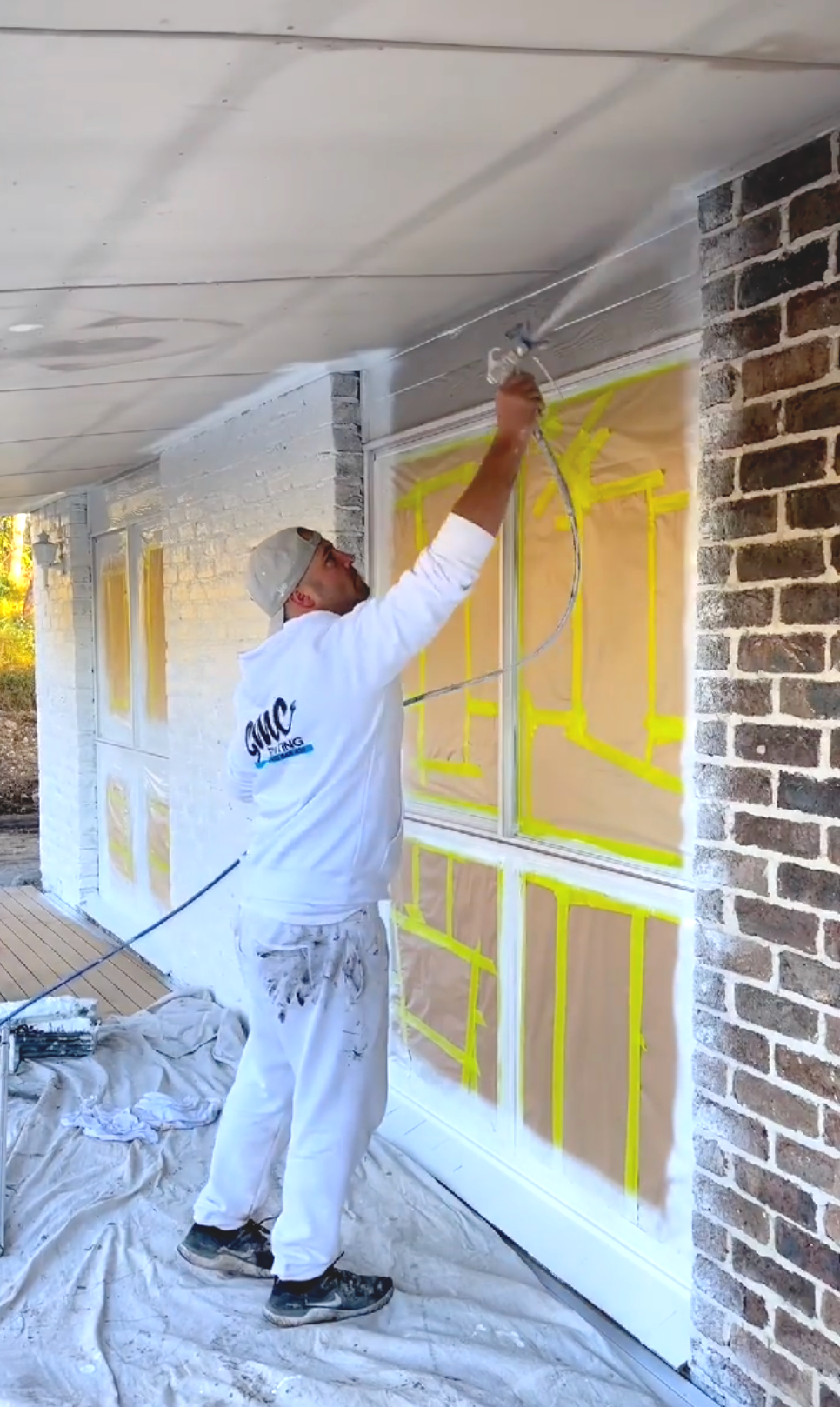 Man spray painting the outside of a house — Professional Painter on the Gold Coast, QLD