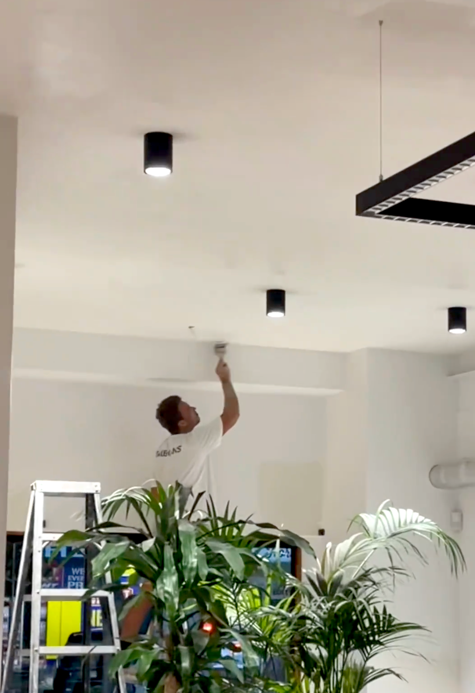 Guy painting a white roof - Exterior Painting on the Gold Coast, QLD