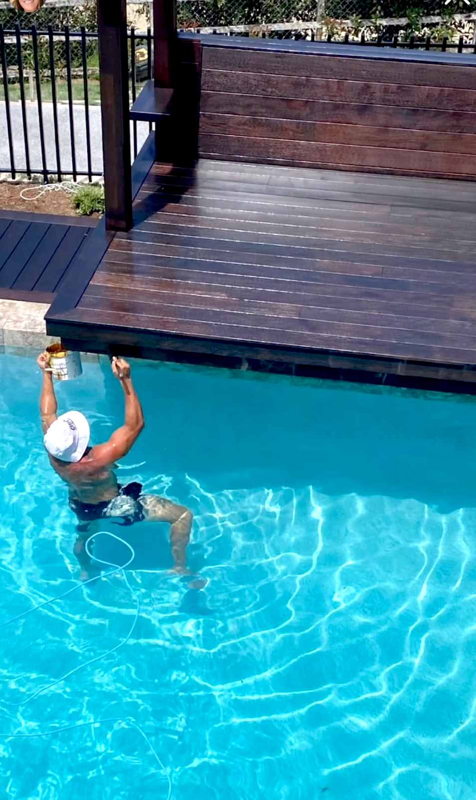 Guy painting a patio while ib a pool — Professional Painter on the Gold Coast, QLD
