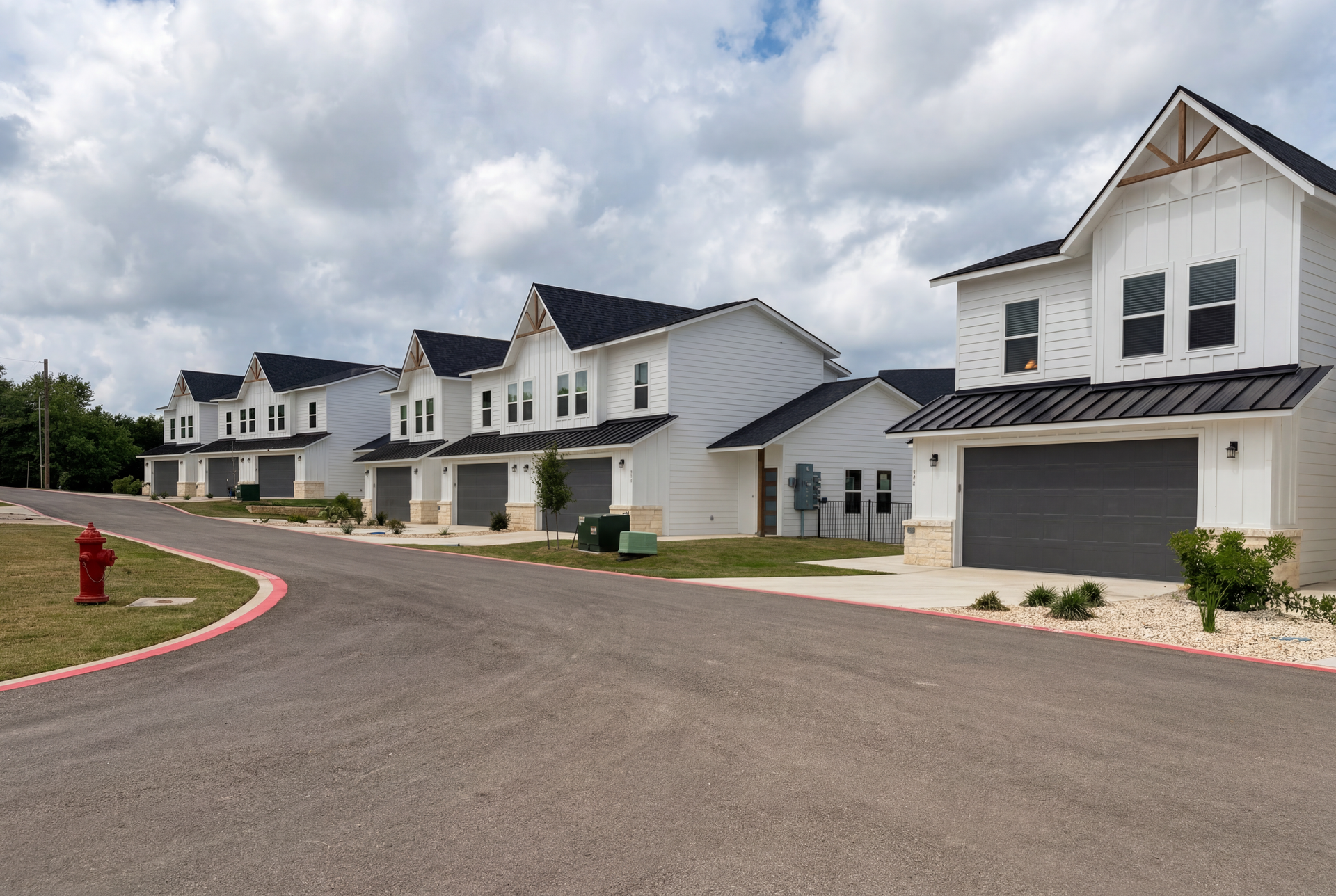 A woman is pouring a drink into a glass at a dinner table.