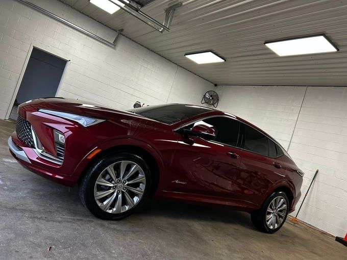 Red Cadillac Lyriq SUV in a garage, angled view.