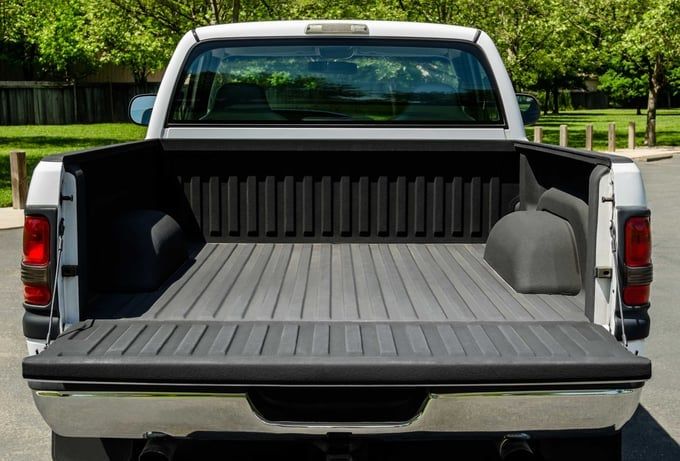 White pickup truck bed with open tailgate, lined with dark bed liner.