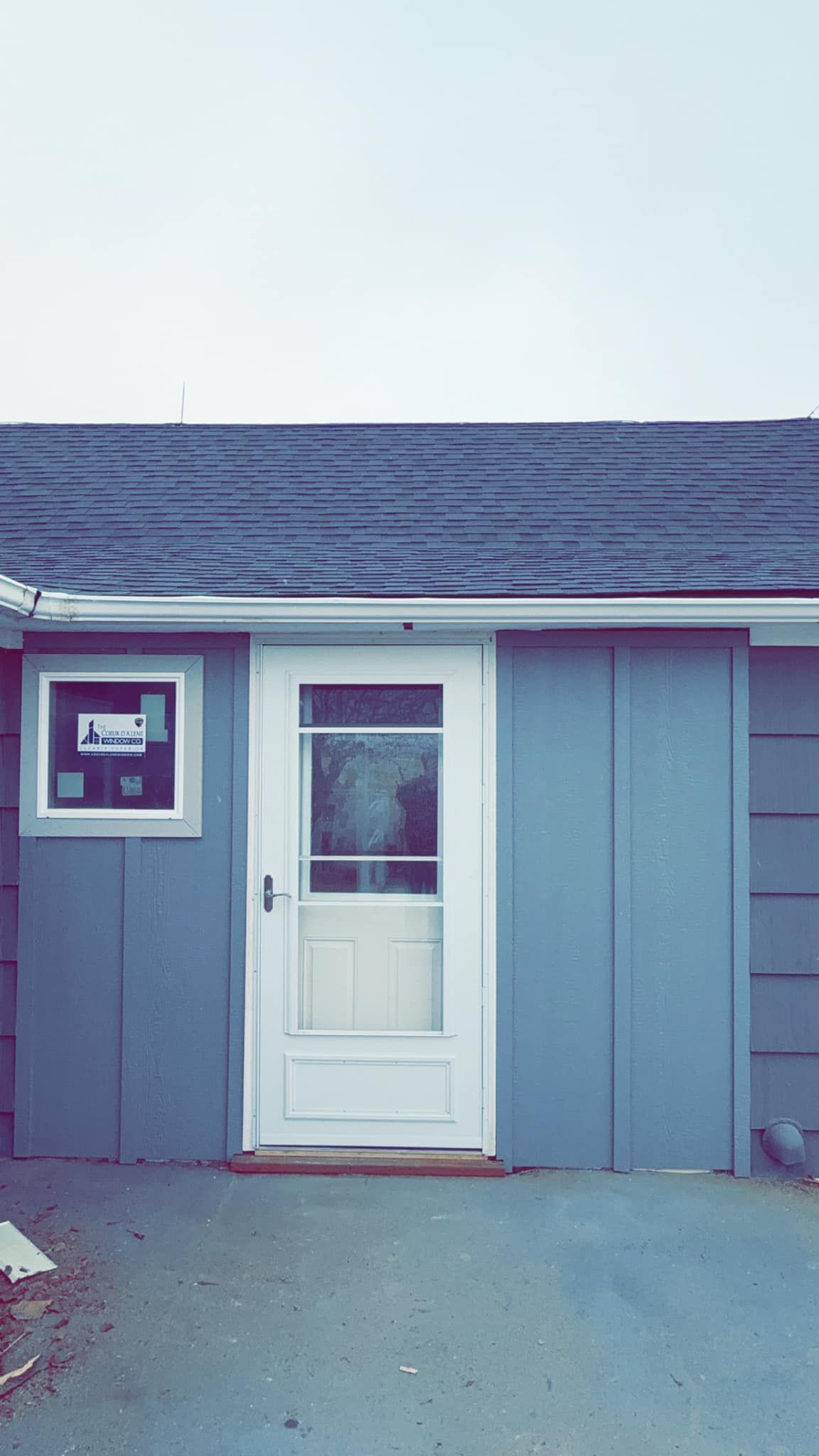 A small blue house with a white door and window.