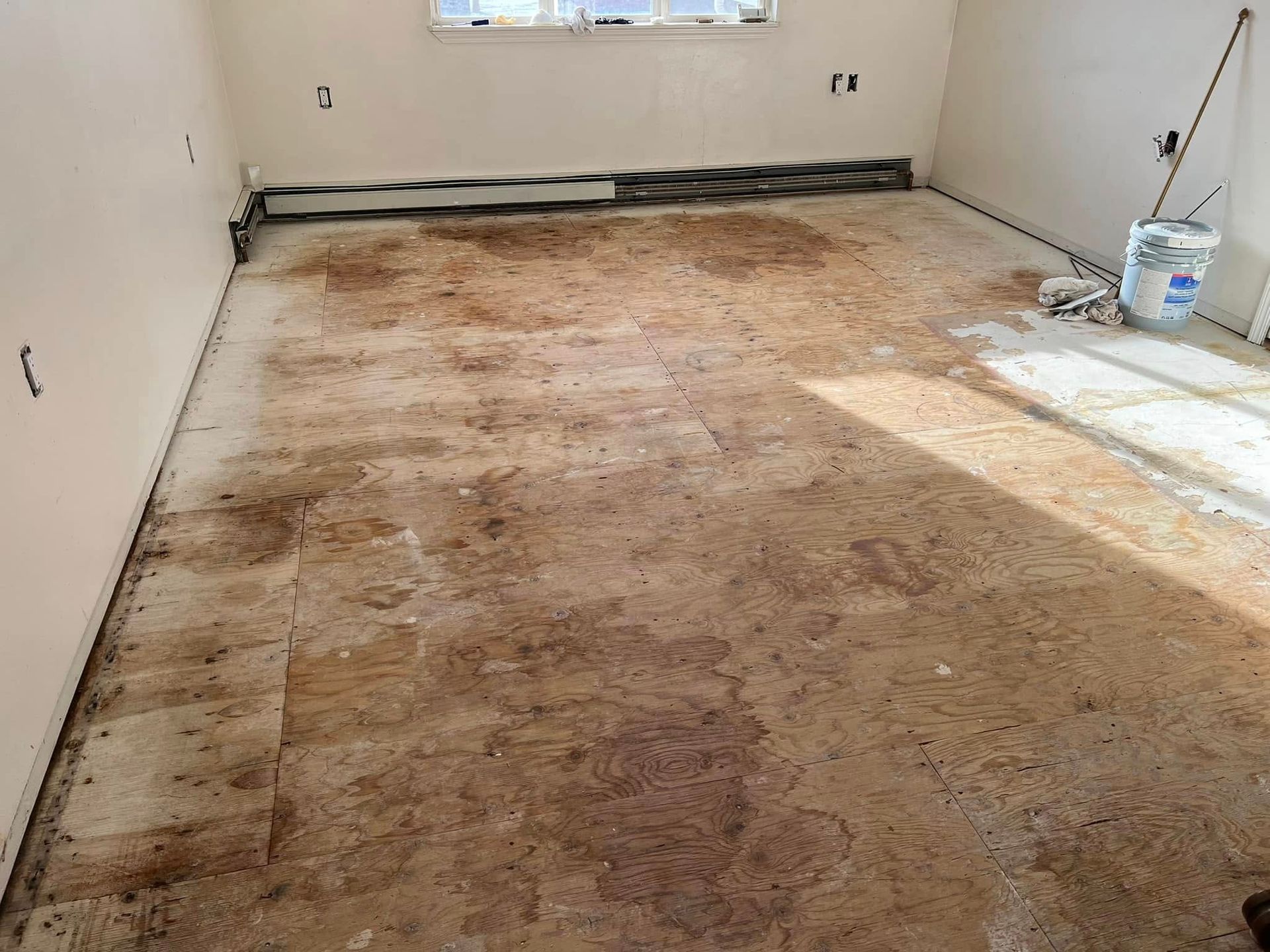 A room with a dirty floor and a window.