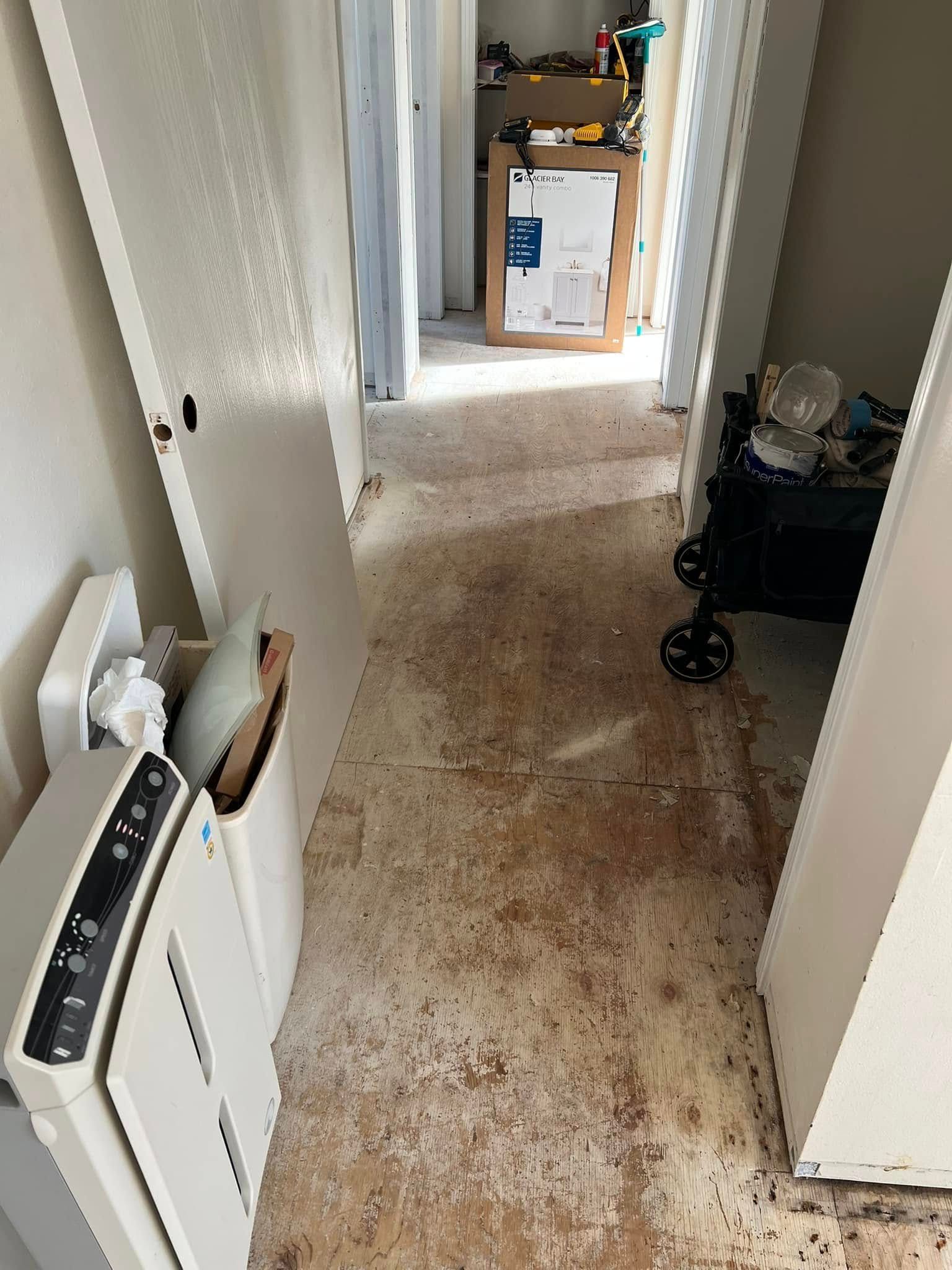 A hallway in a house with a dirty floor and a stroller.
