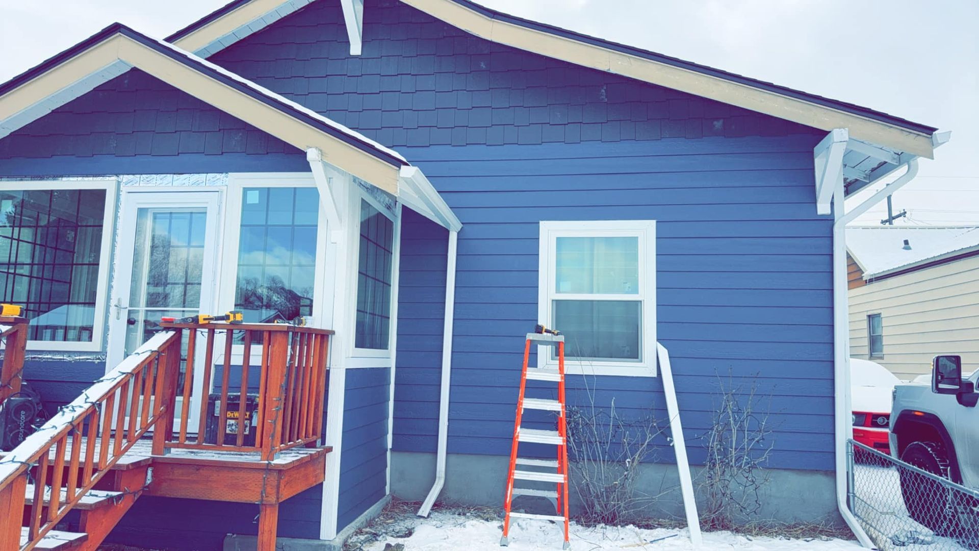 A blue house with a ladder in front of it.