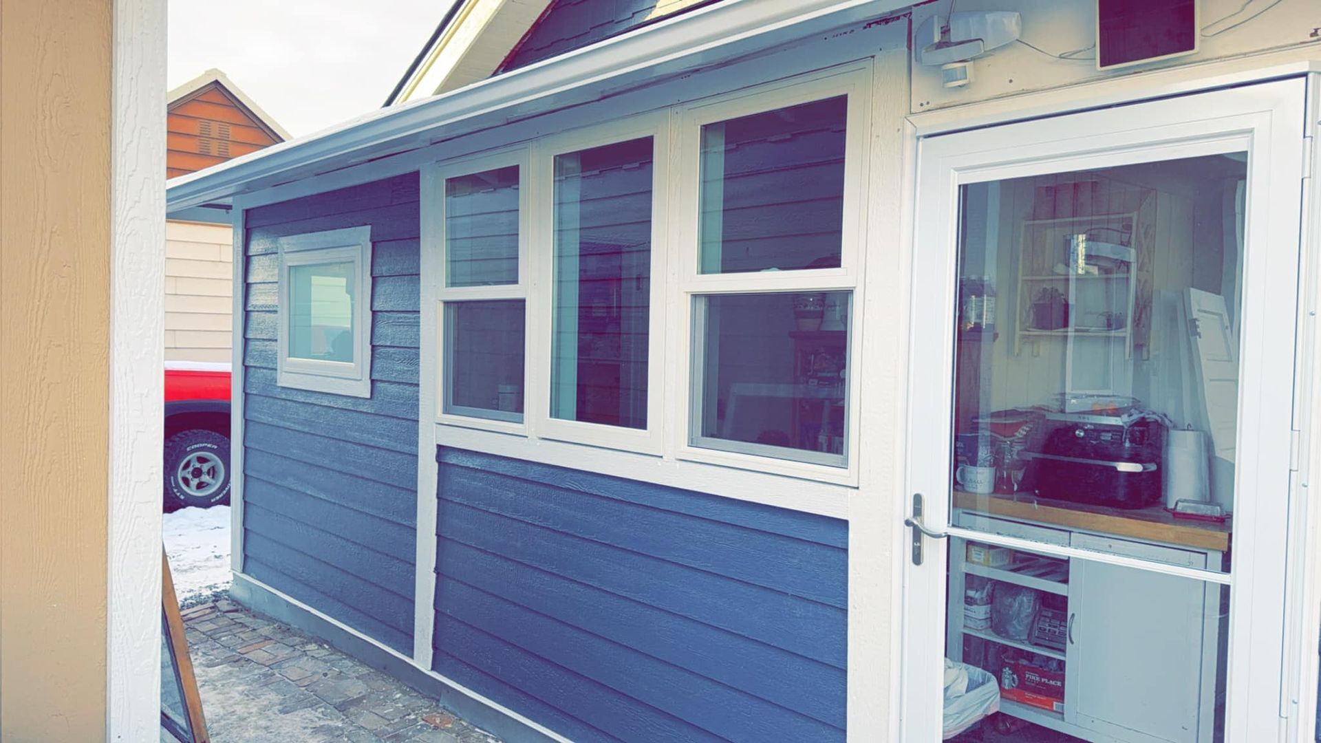 A blue and white house with a kitchen and a door.