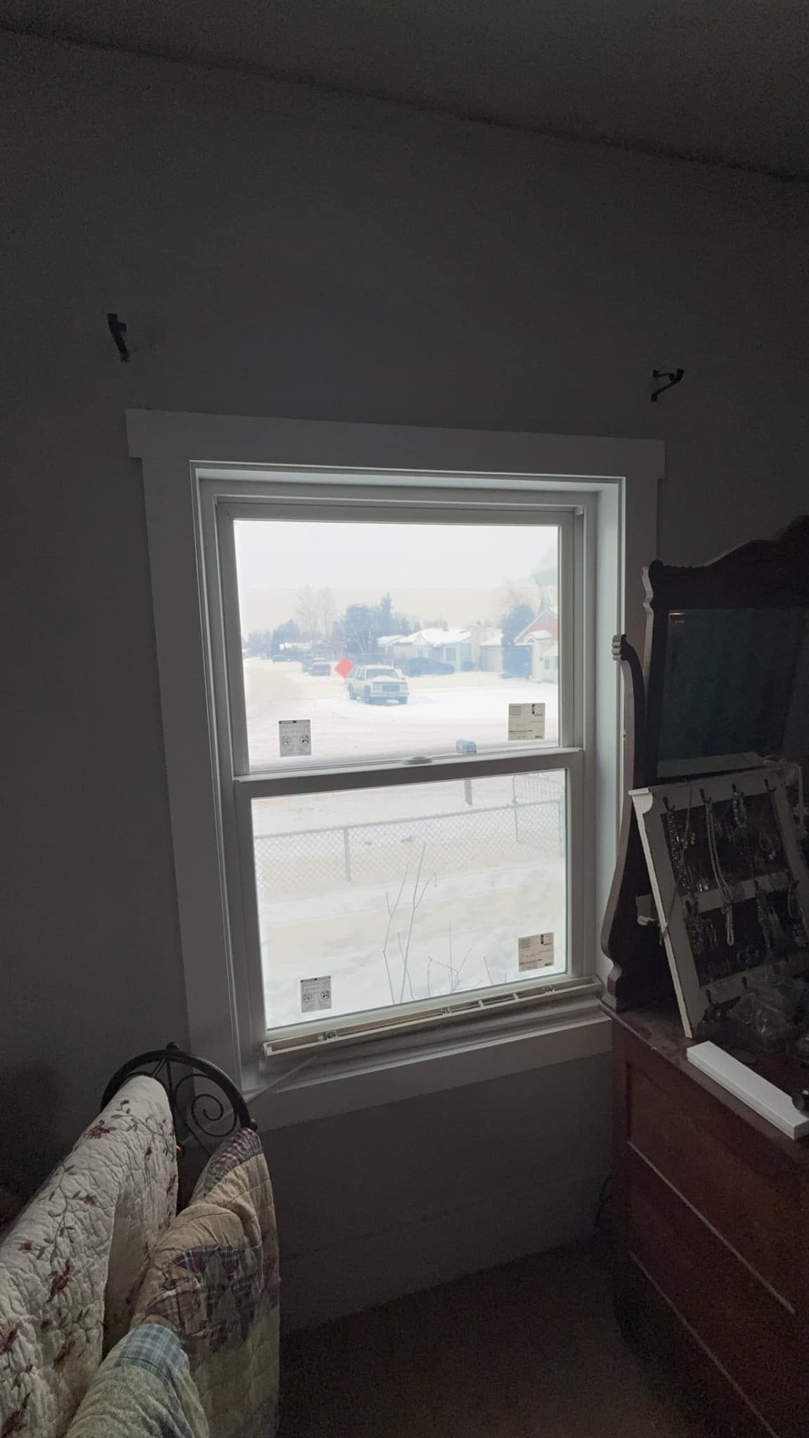 A bedroom with a window looking out to a snowy field.