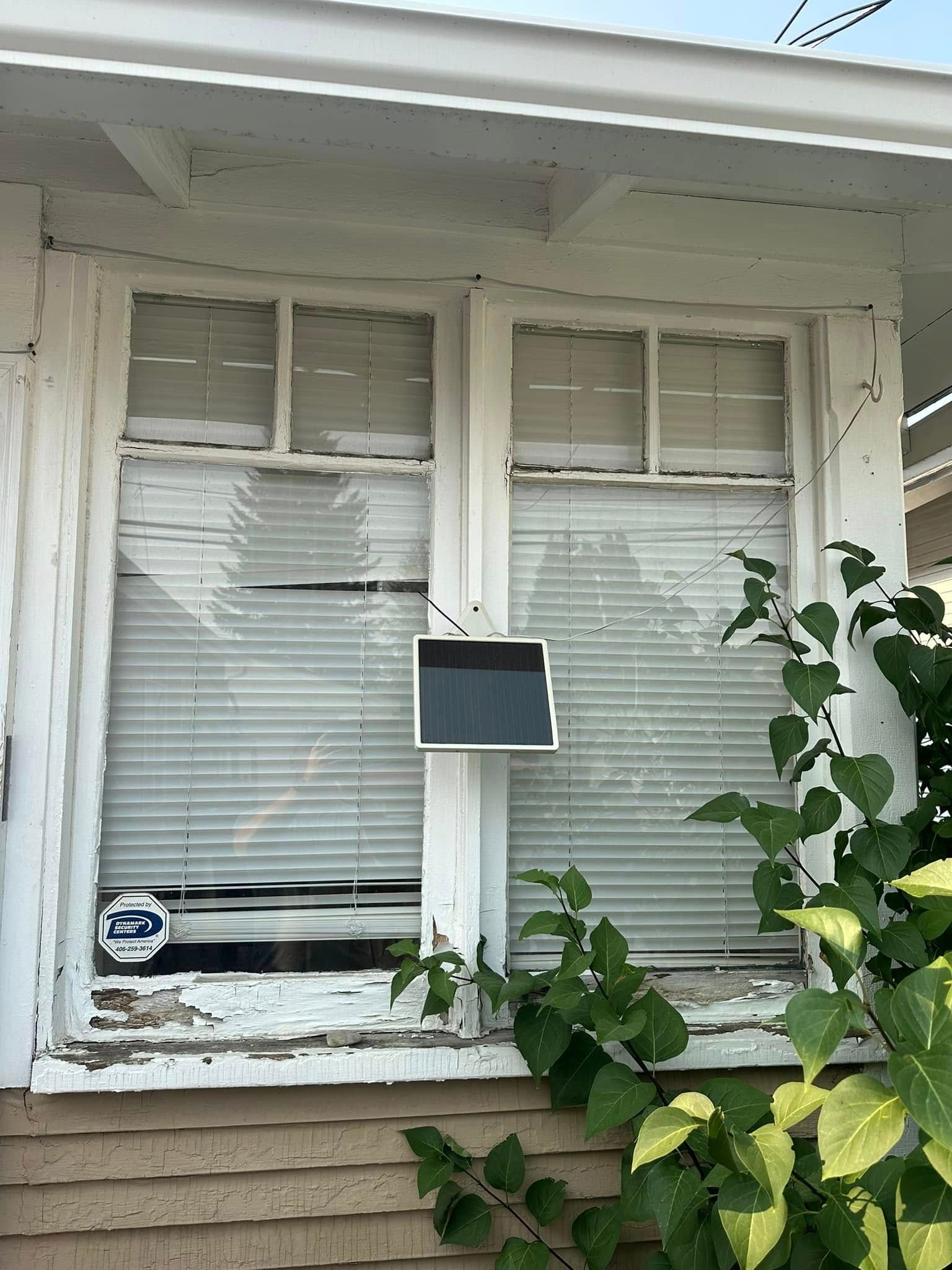 A broken window with a solar panel attached to it