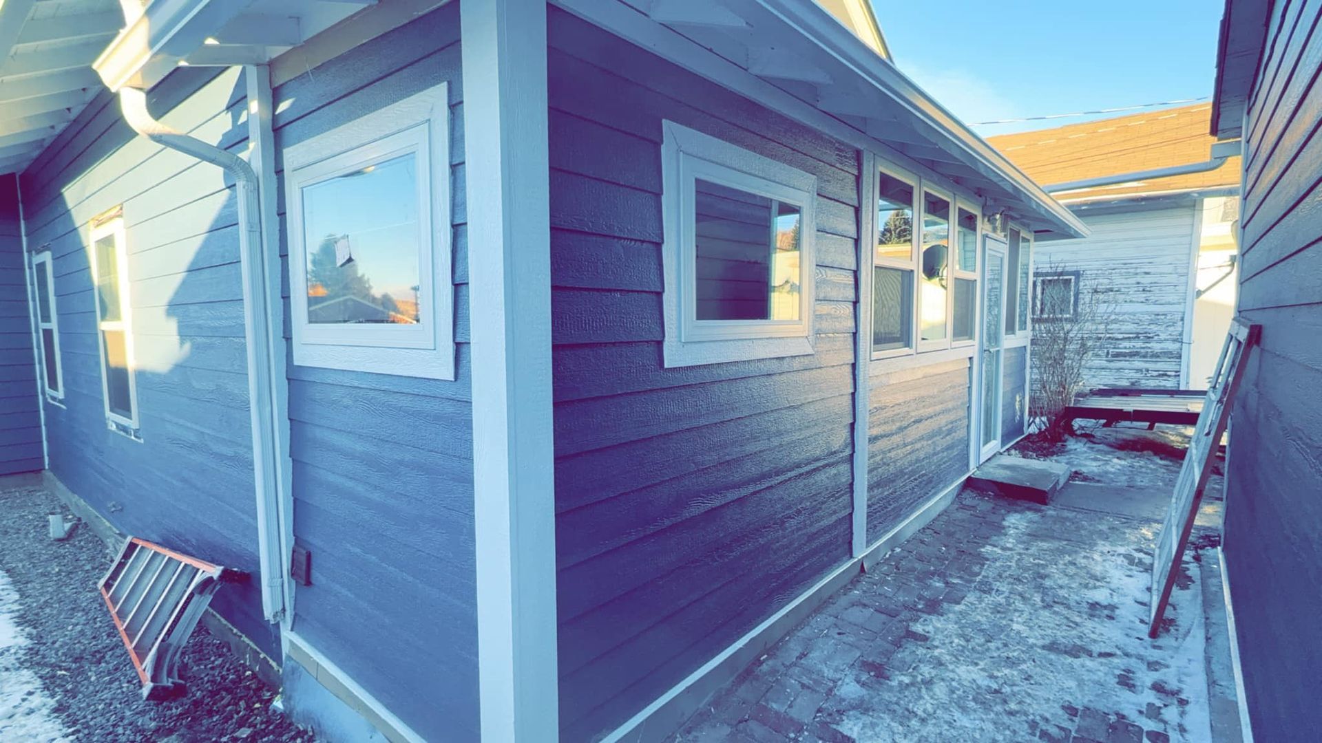 A house with a lot of windows and a ladder on the side of it.
