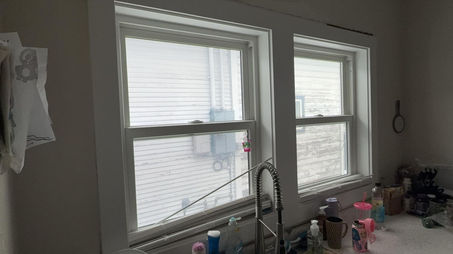 A kitchen with two windows and a sink.