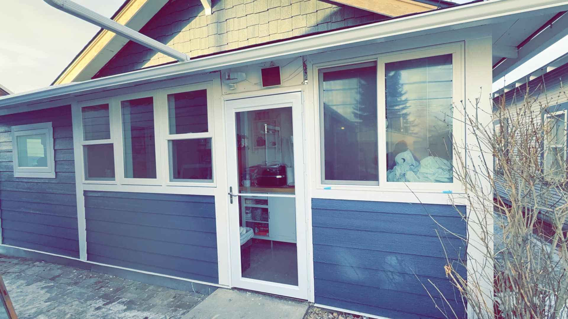 A blue house with a white door and windows