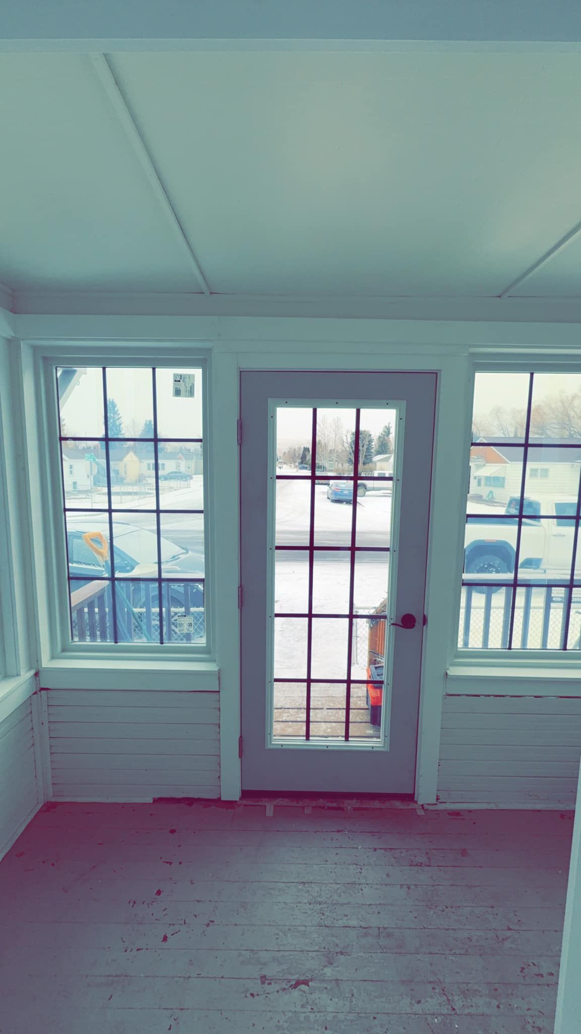 An empty room with a door and a lot of windows.