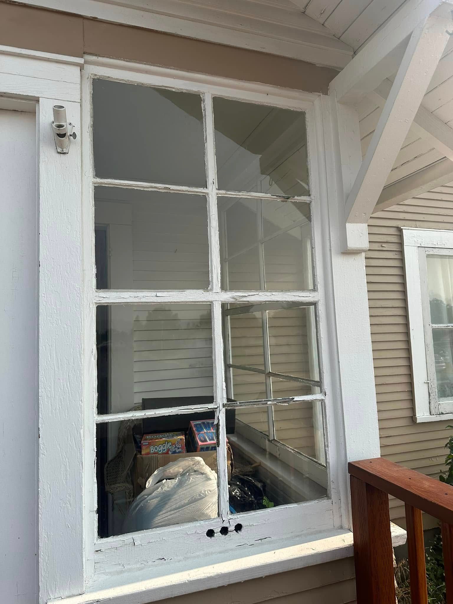 A broken window on the side of a house.
