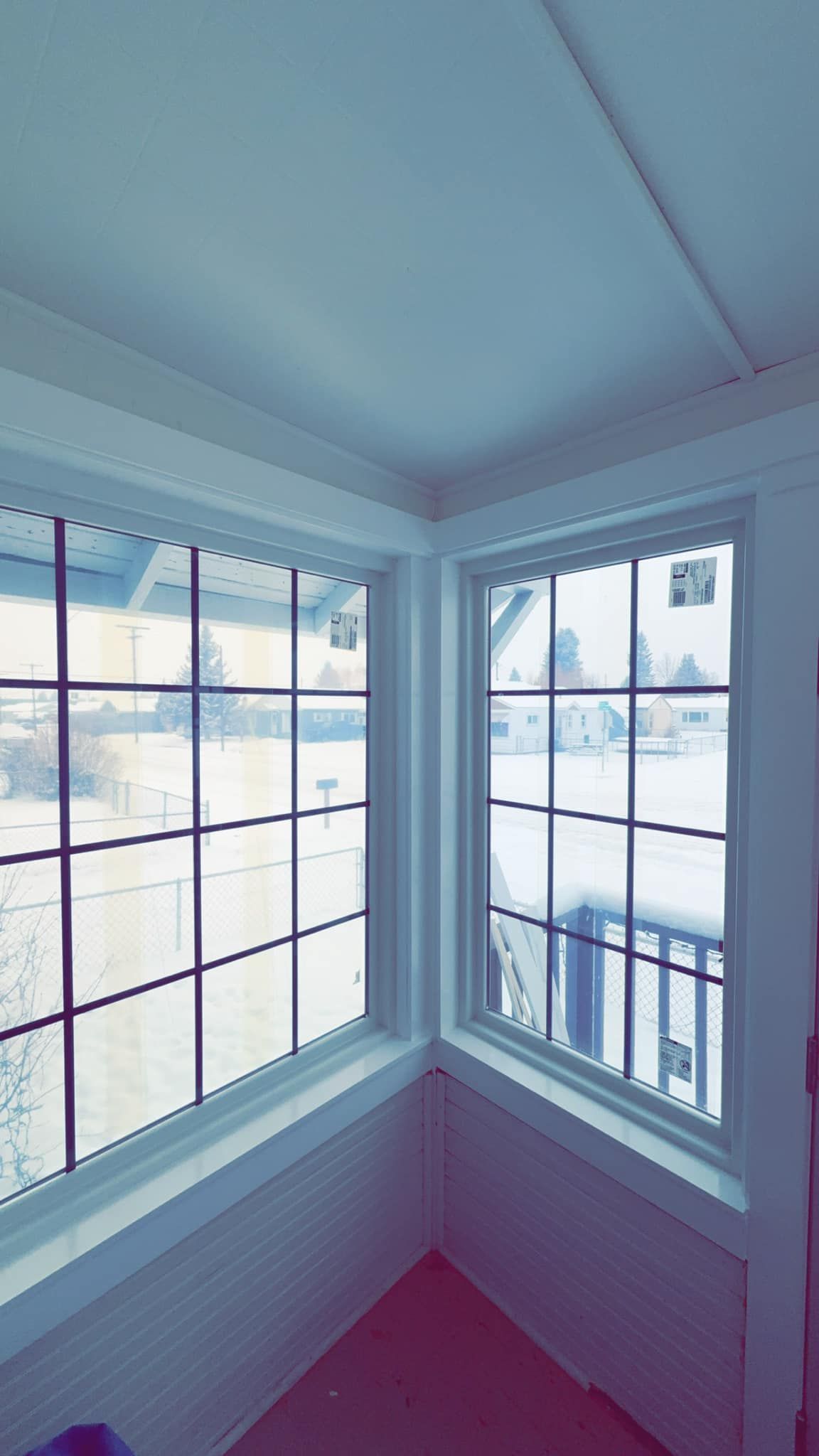 A room with a lot of windows and a view of the snow outside.