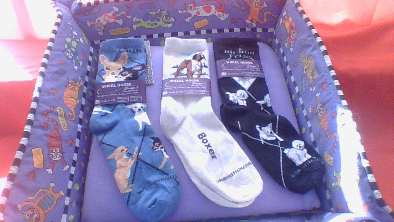 Three pairs of boxer socks in a purple box.