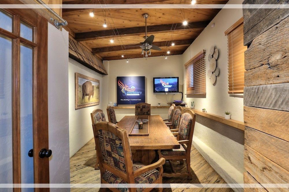 A dining room with a table and chairs and two televisions