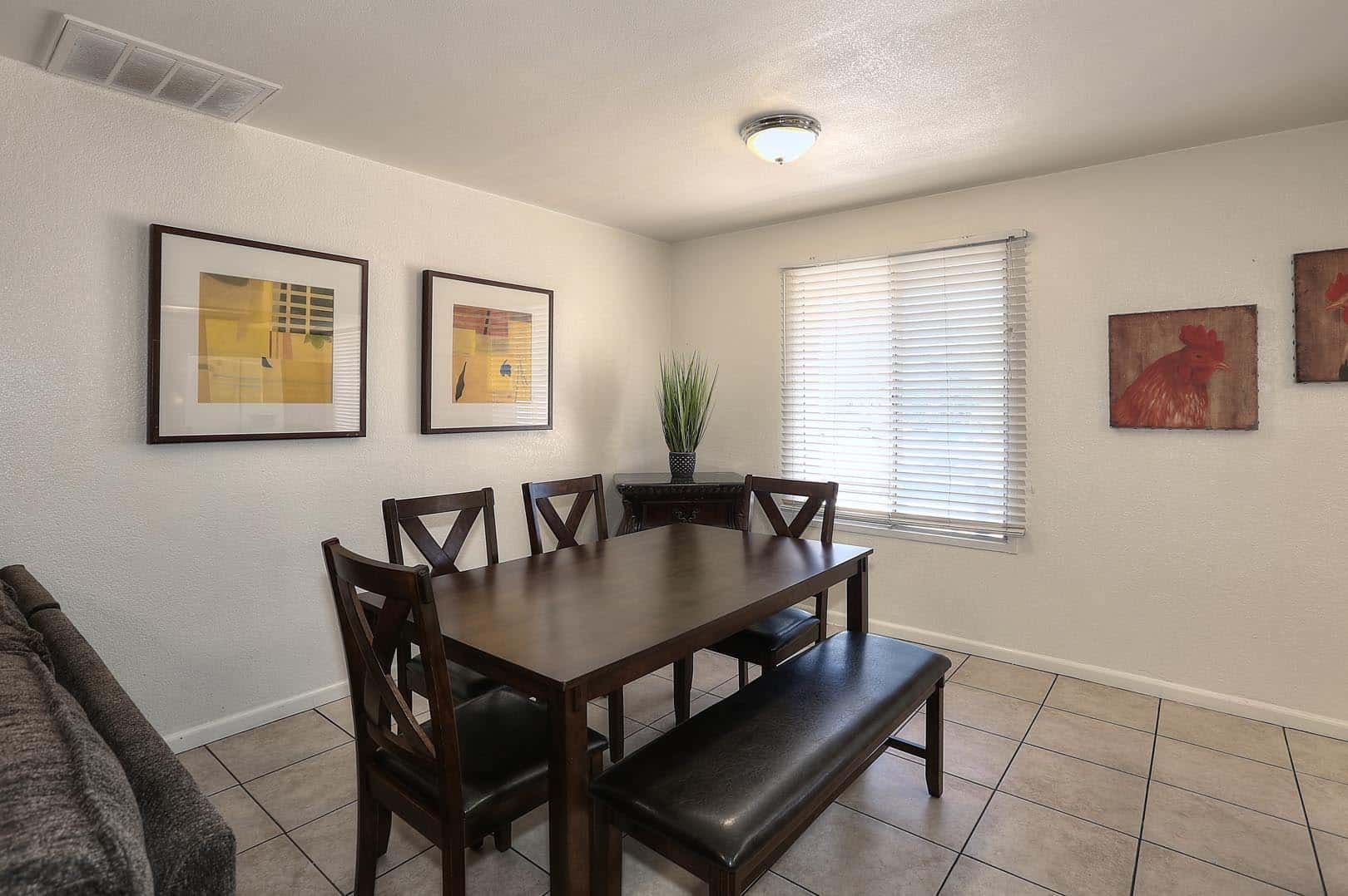 A dining room with a table and chairs and a bench