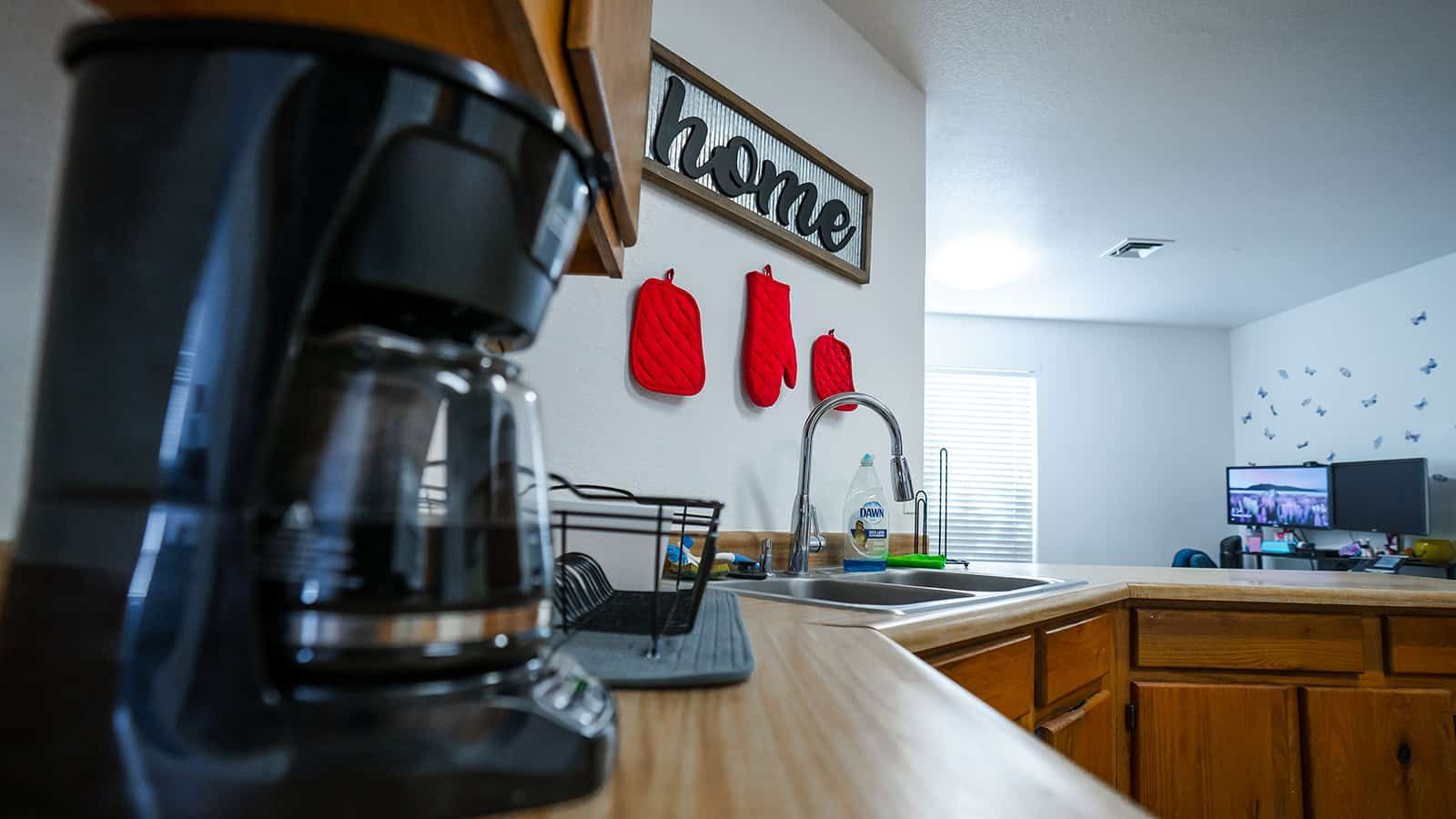 A coffee maker is sitting on a kitchen counter next to a sink.