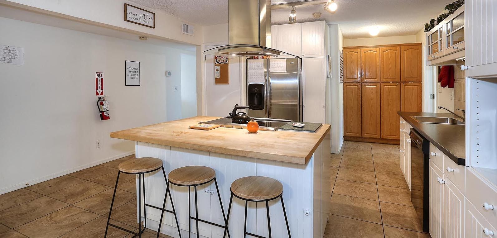 A kitchen with a large island and stools