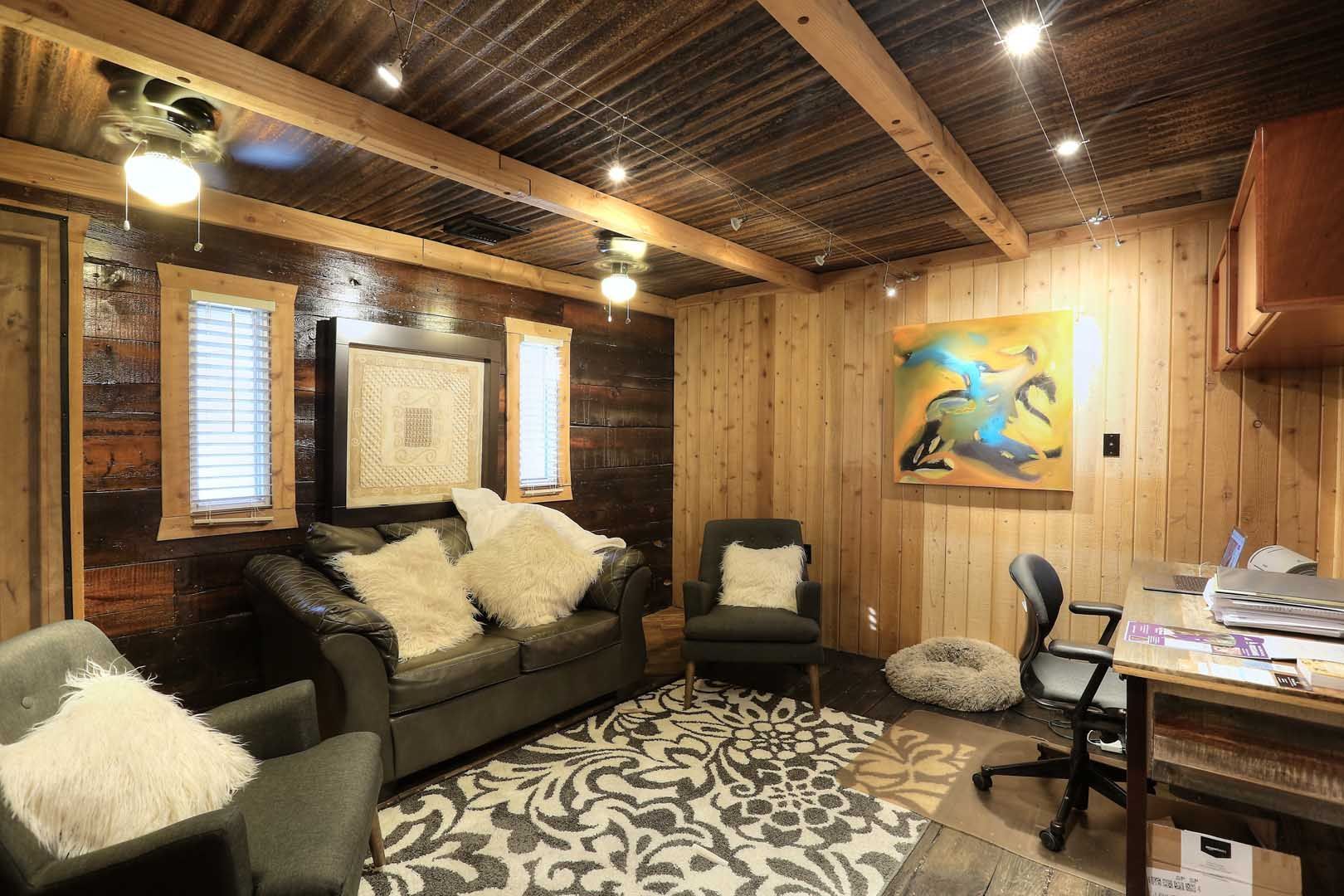 A living room with a couch , chairs , and a desk.