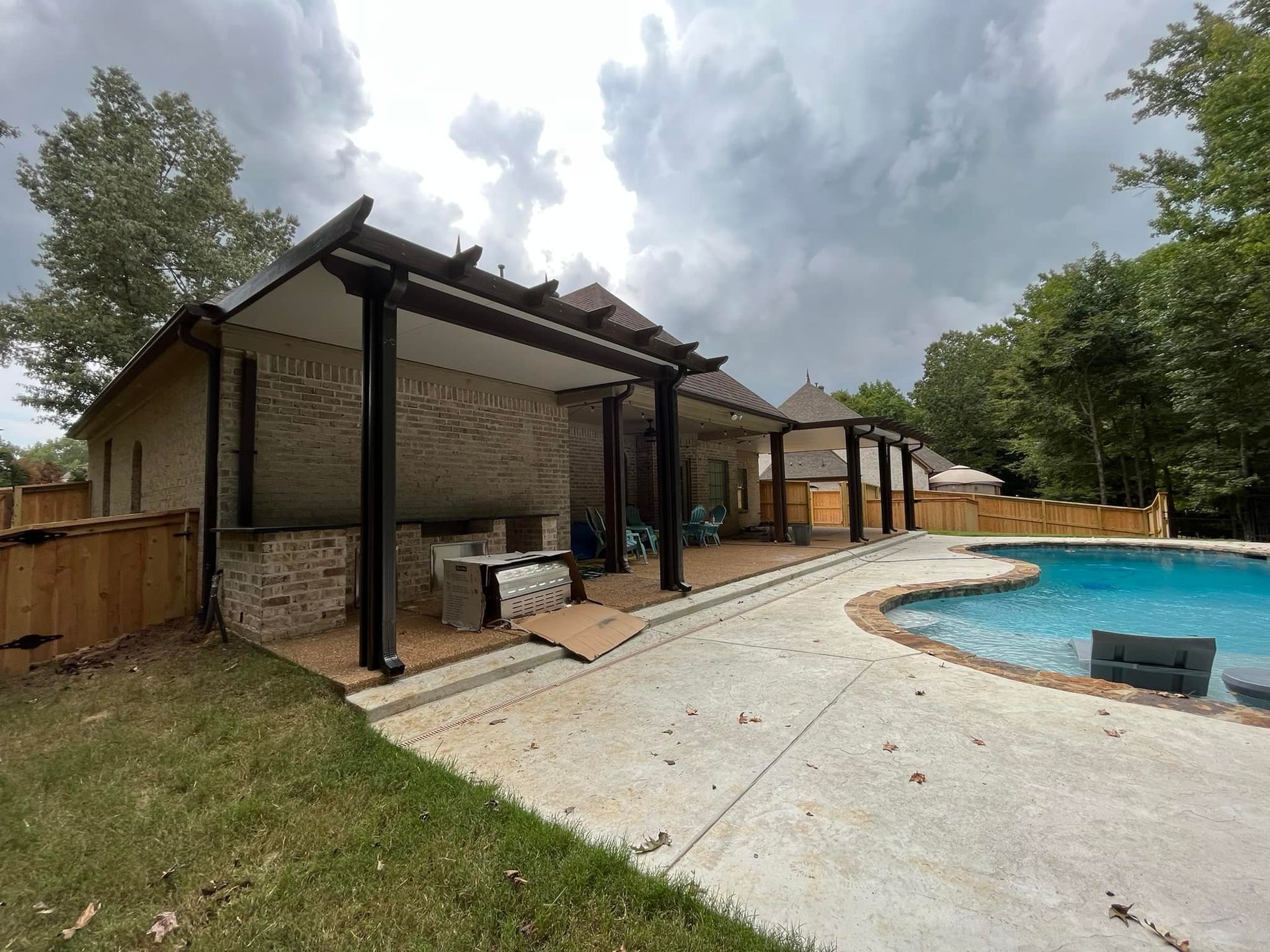 There is a large swimming pool in the backyard of a house.