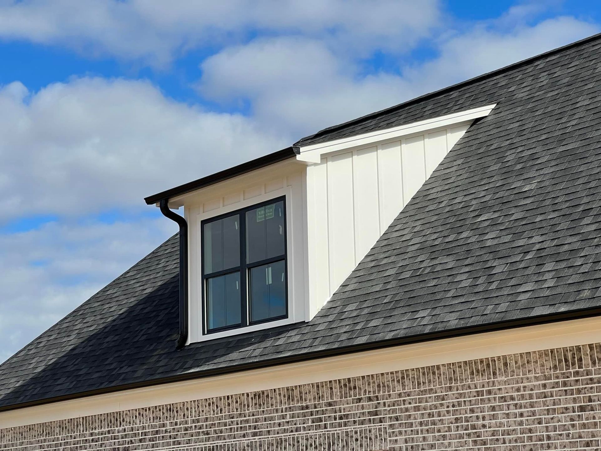 A brick house with a window on the roof.