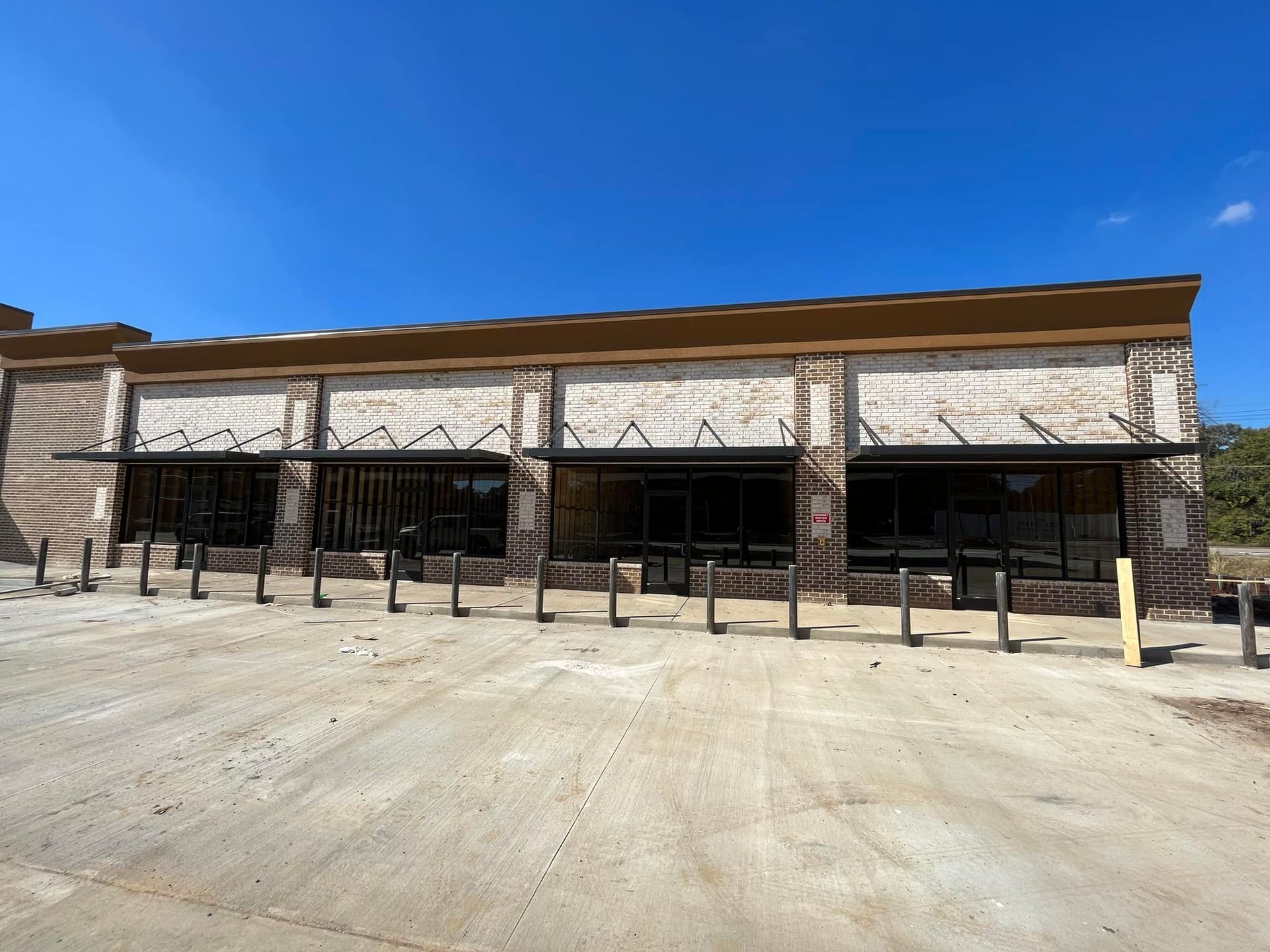 A large brick building with a lot of windows and a parking lot in front of it.