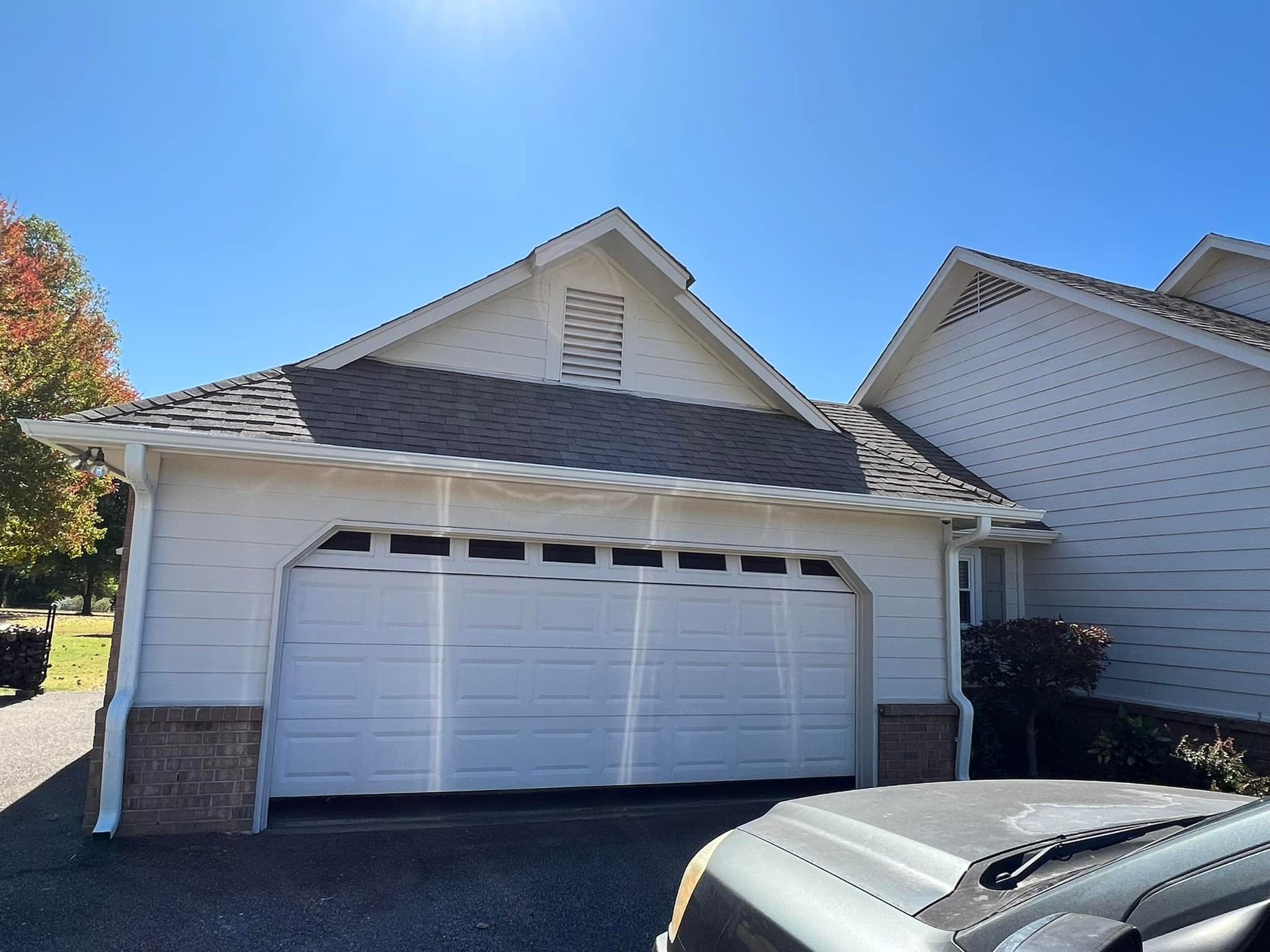 A white garage with a car parked in front of it