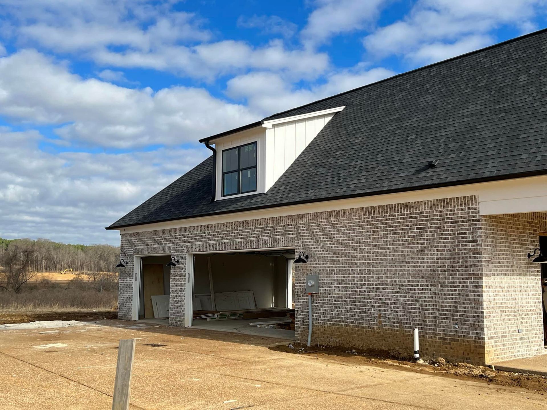 A brick house with a black roof and a window