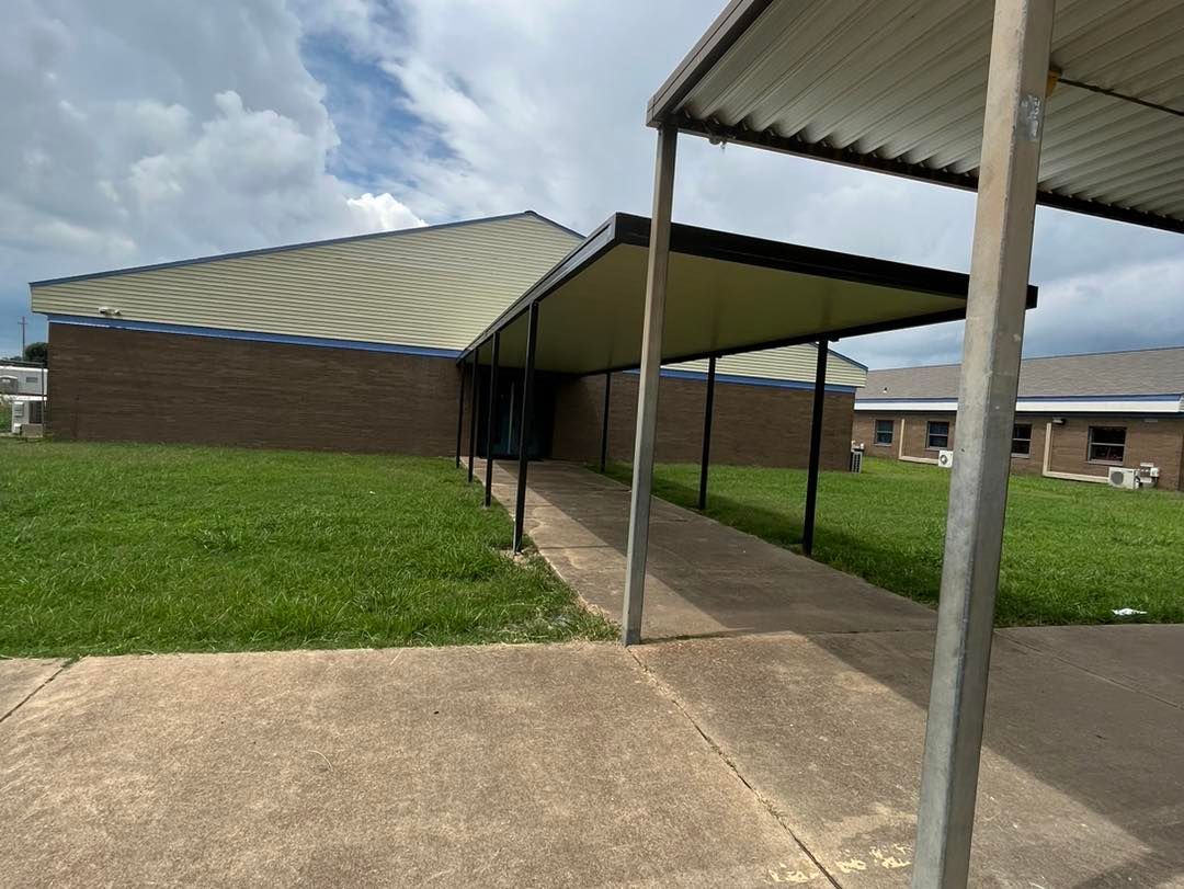 A brick building with a covered walkway leading to it.
