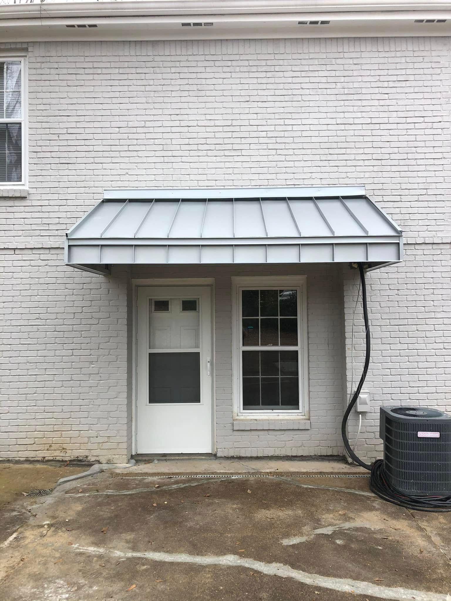 A brick building with a blue awning and a sign that says dry clean.