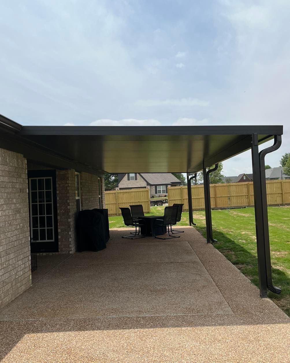 A patio with a table and chairs under a canopy.