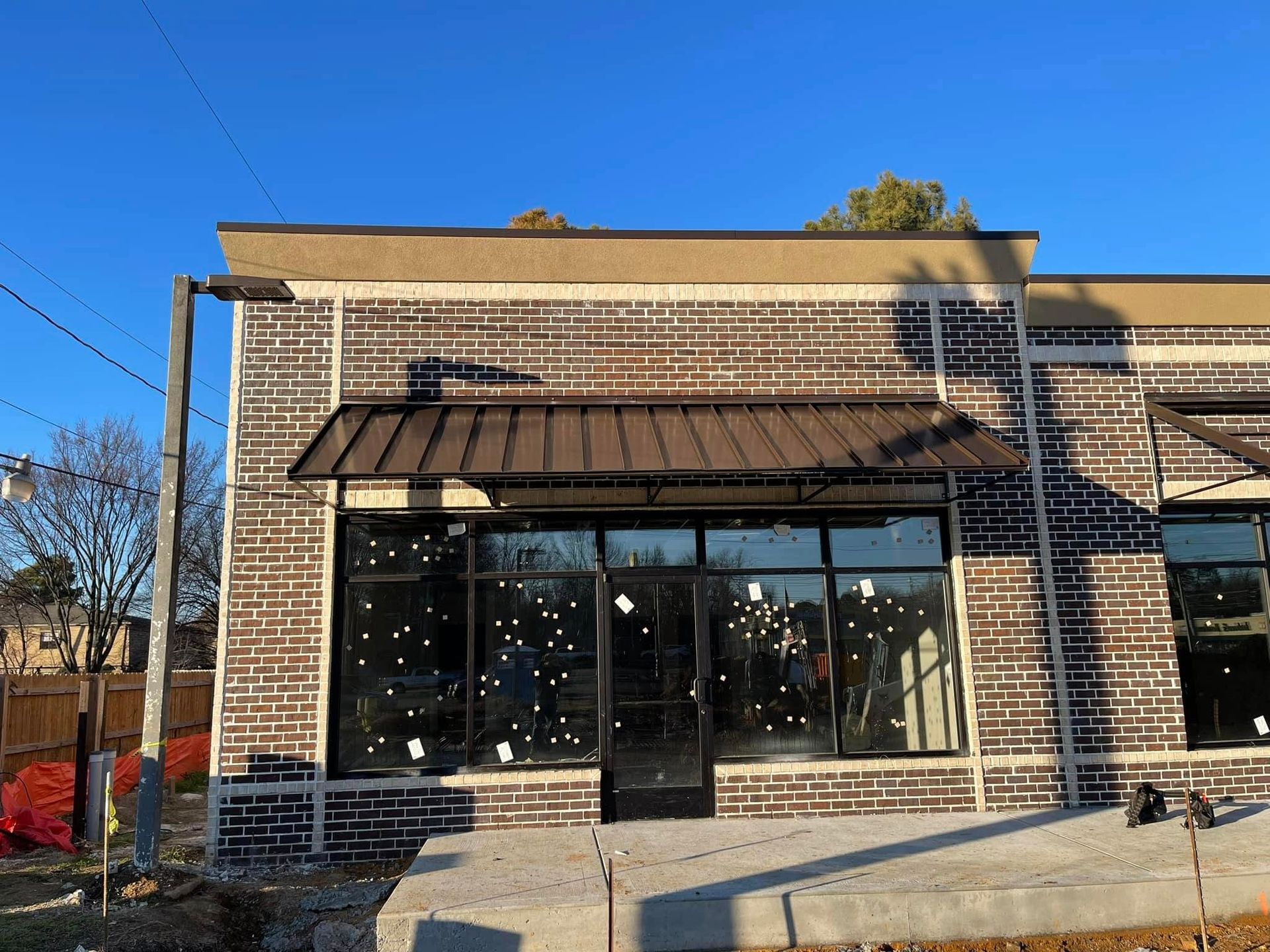 A brick building with a metal awning on the front of it.