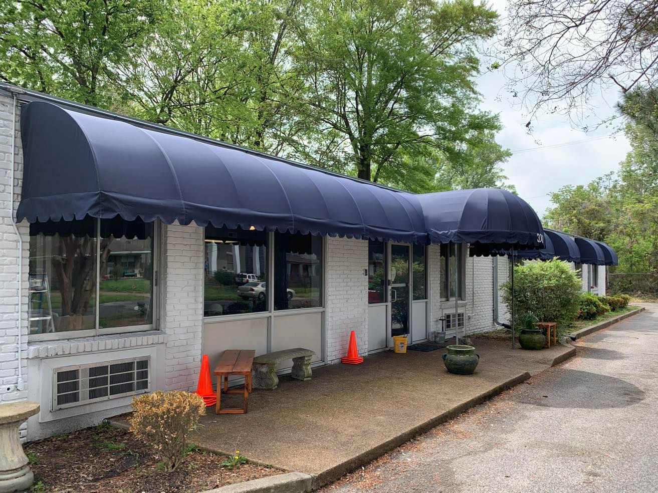 A white building with blue awnings on the side of it.