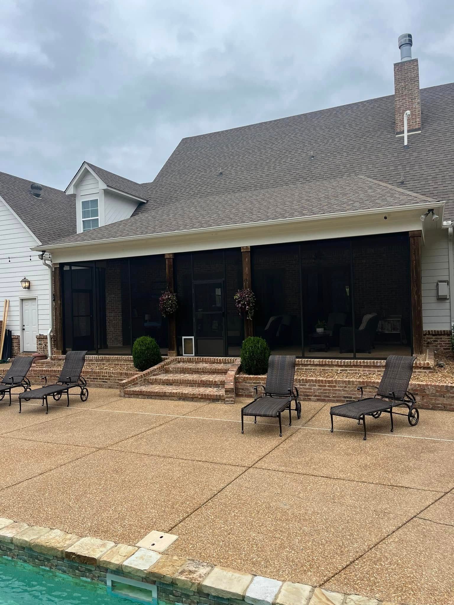 A house with a screened in porch and a swimming pool.
