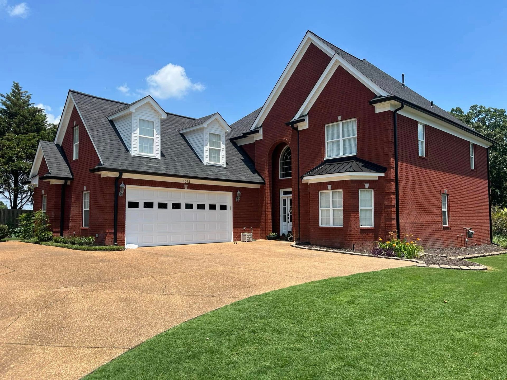A large red brick house with a white garage door