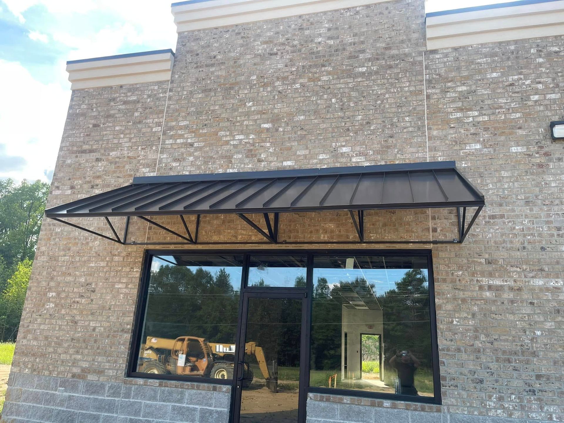 A brick building with a canopy over the door and windows.