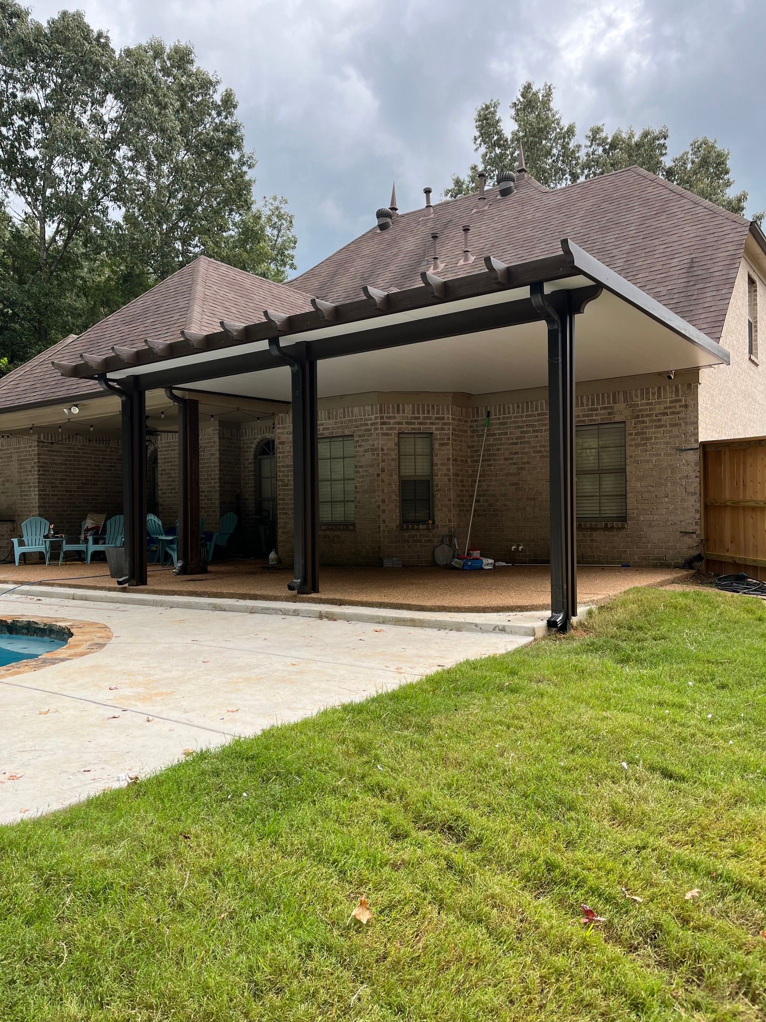 A house with a covered patio and a pool in the backyard.