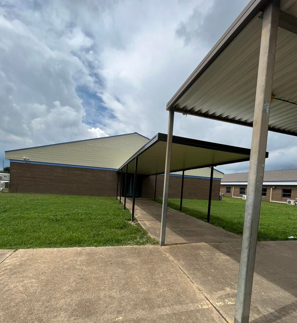 A brick building with a covered walkway leading to it.