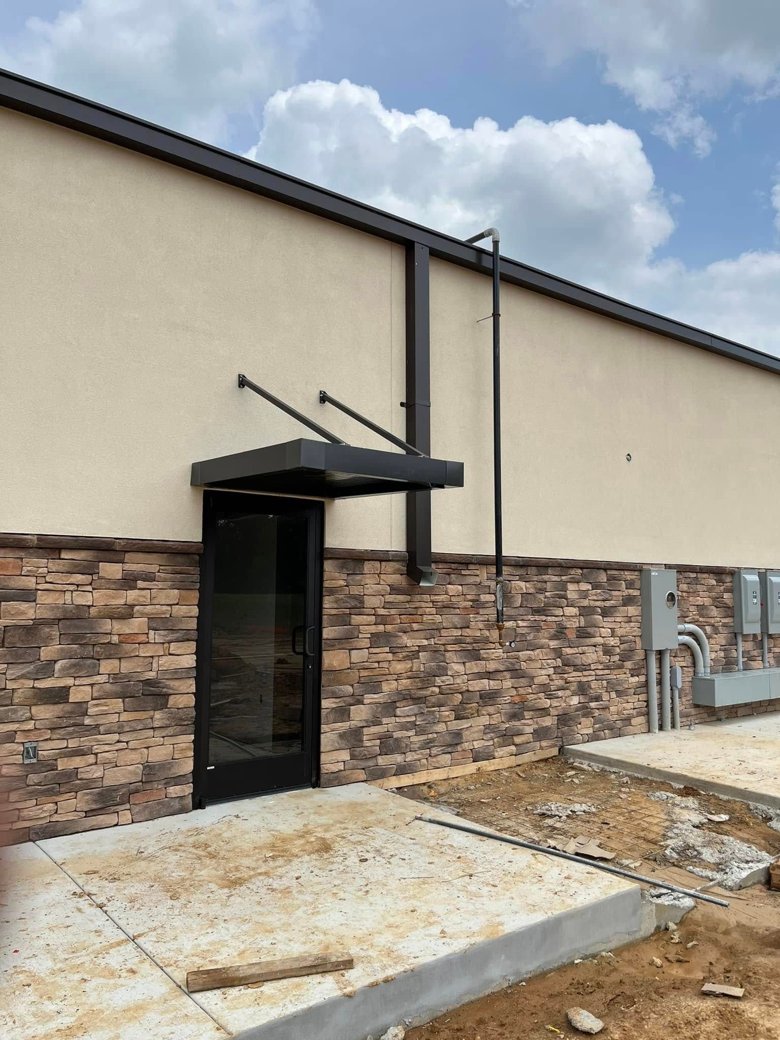 A building under construction with a canopy over the door.