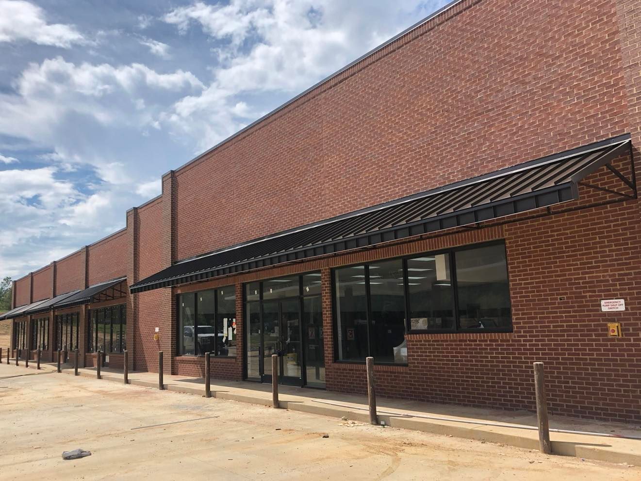 A brick building with a black awning on the side of it.
