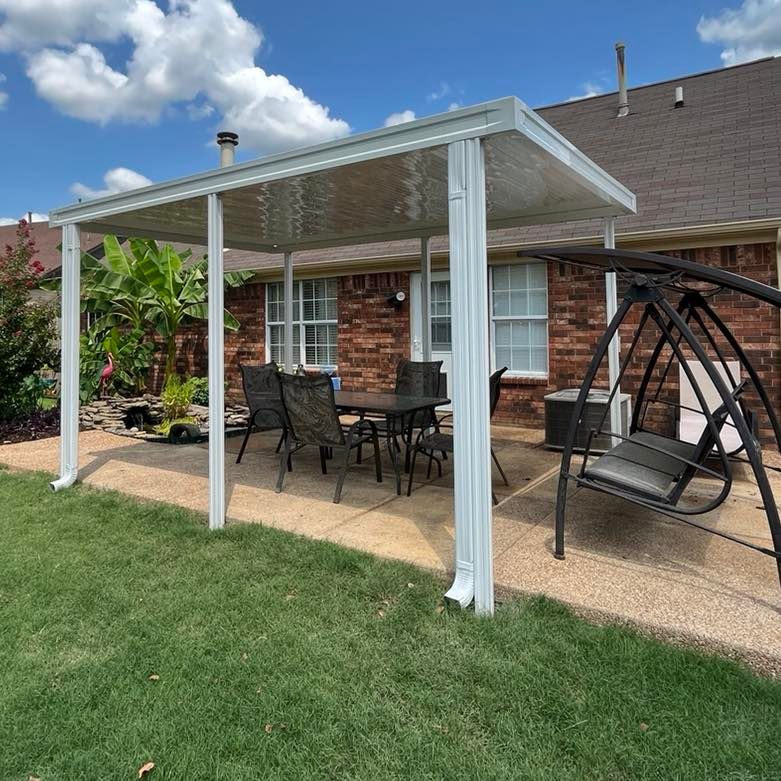 A patio with a table and chairs under a canopy and a swing.
