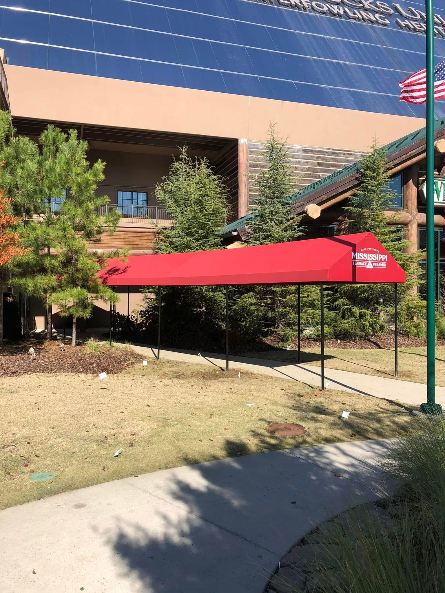 A brick building with a white awning and a car parked in front of it