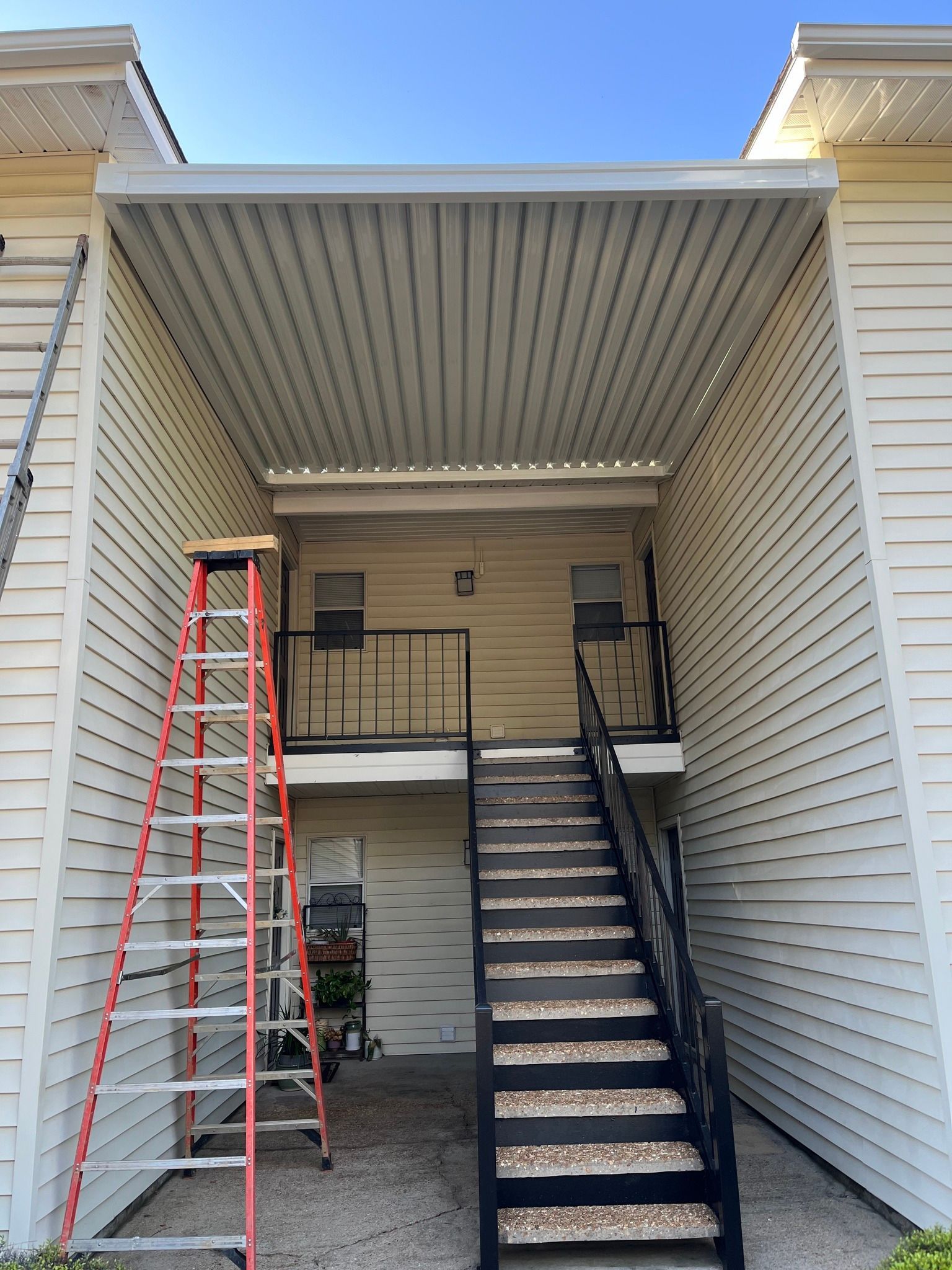 A building with stairs and a ladder in front of it