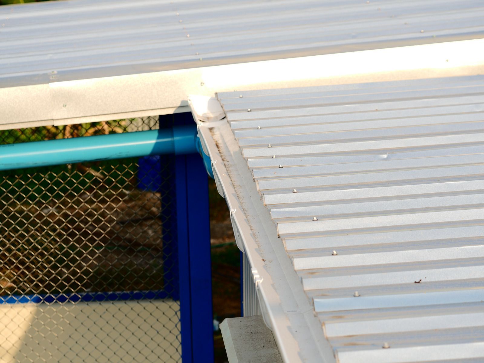 A white roof with a blue fence in the background