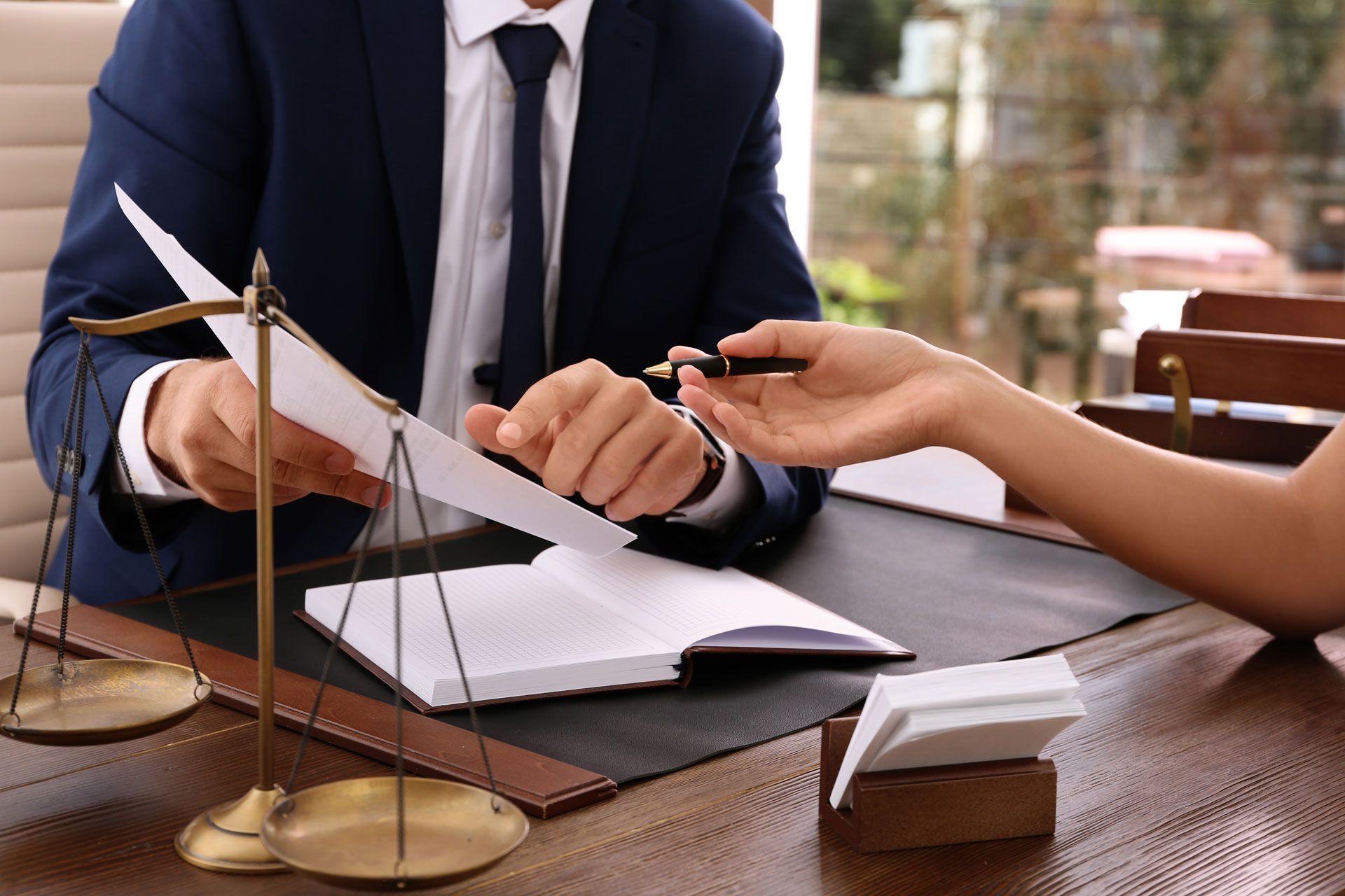 A man in a suit and tie is giving a piece of paper to a woman